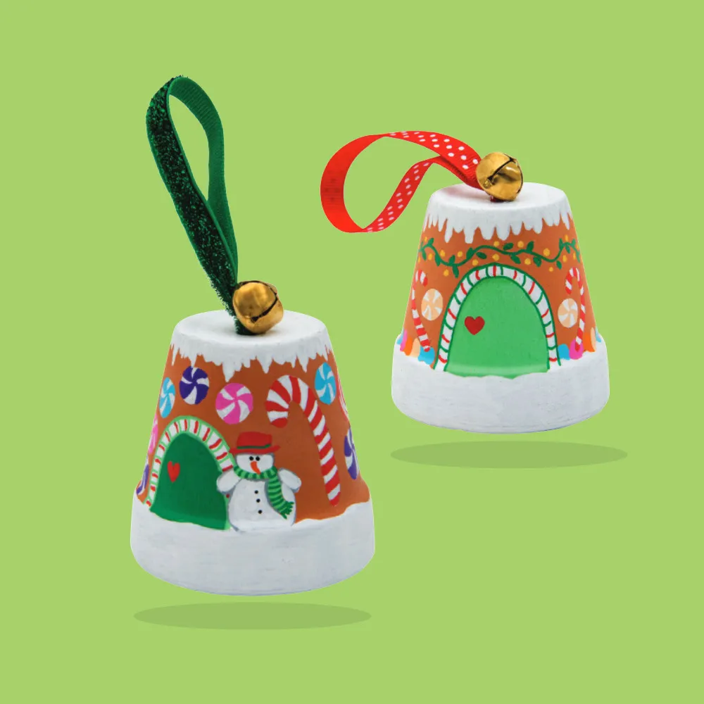 wo upside-down terracotta pot ornaments painted to resemble gingerbread houses, adorned with candy patterns, snow details, and finished with jingle bells and festive ribbon.