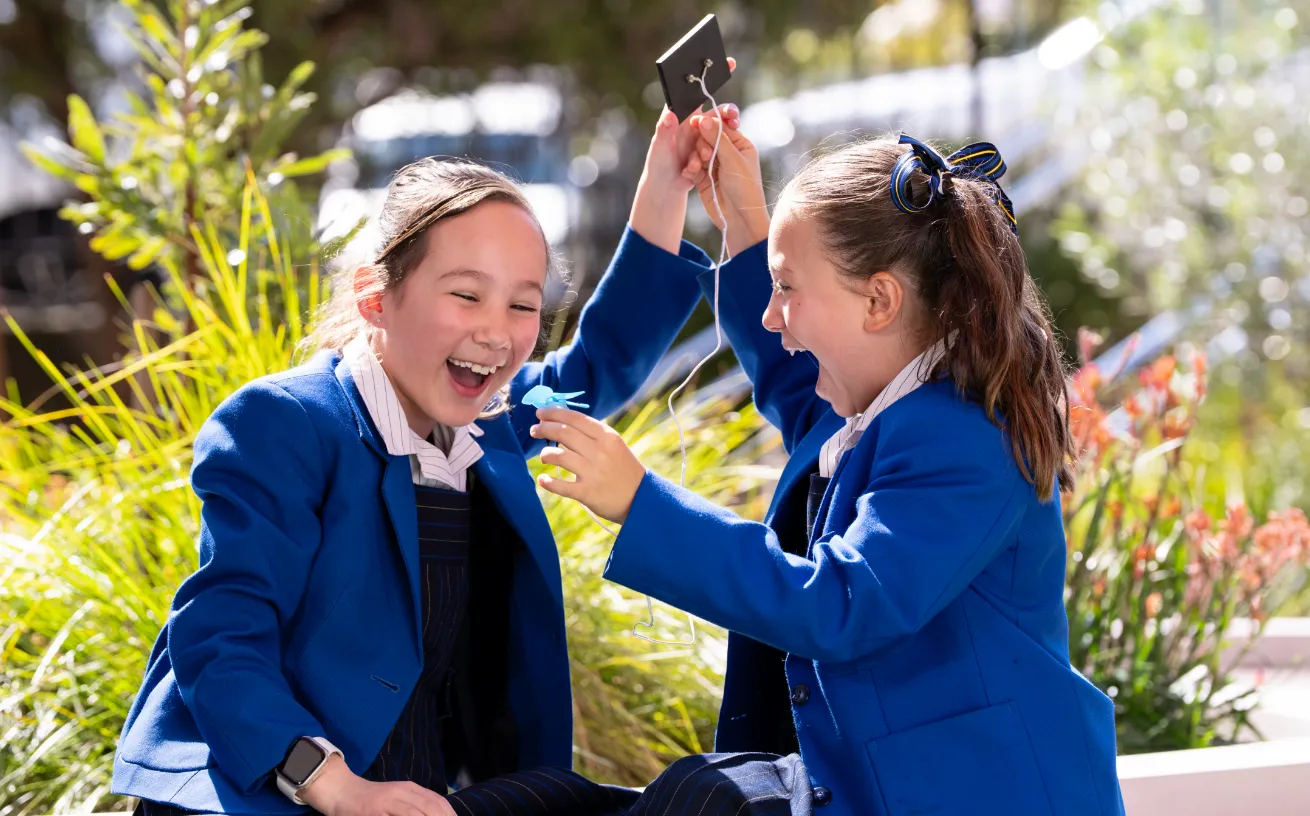 Two primary school girls engaged and enjoying hands-on learning